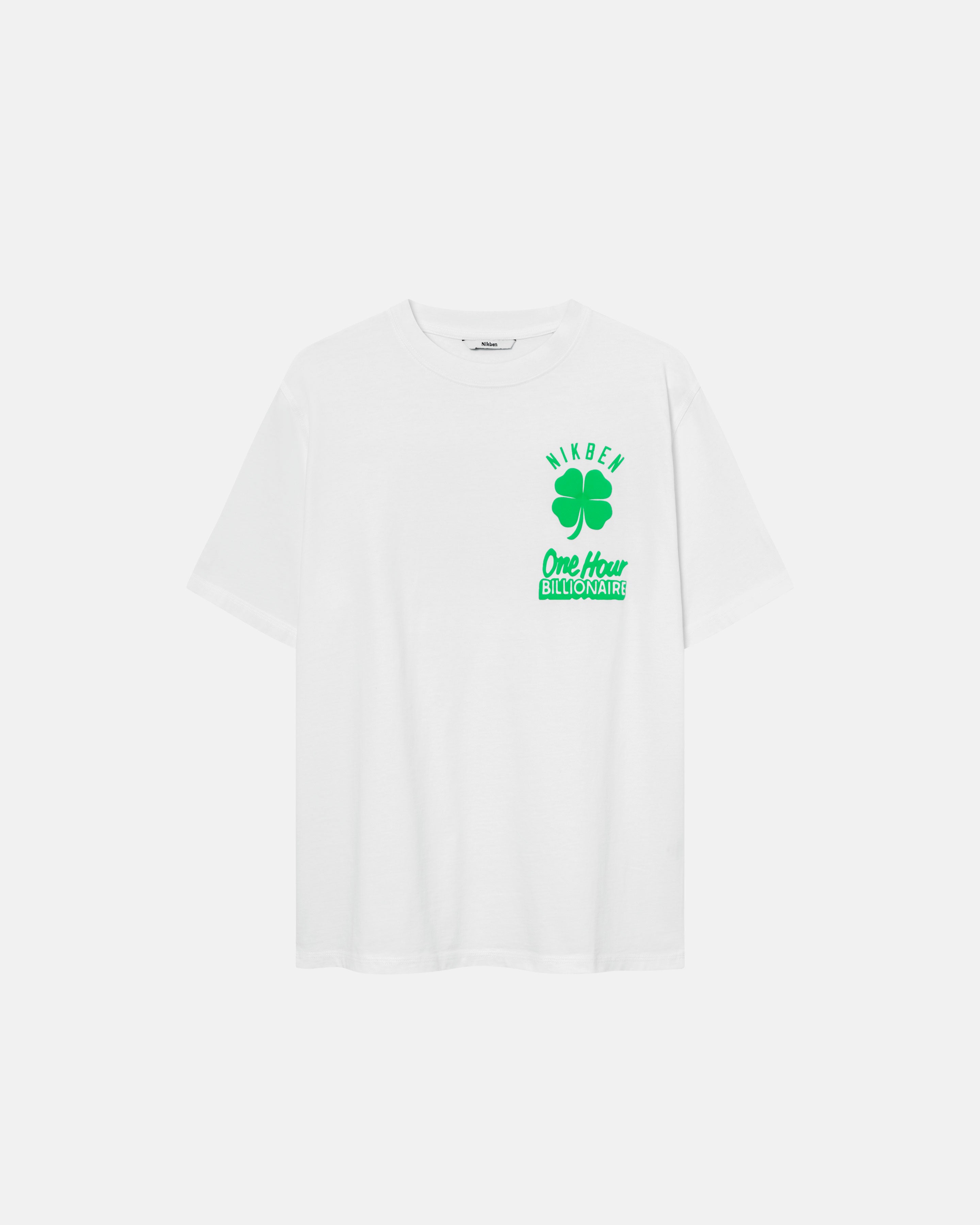 White t-shirt with a green clover print and the text 