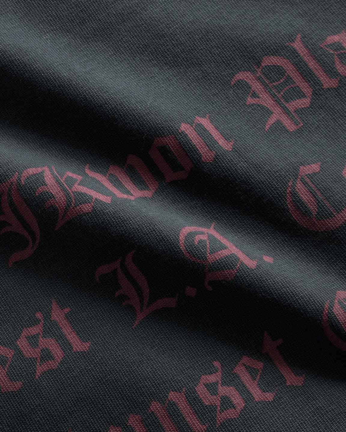 Close up on red text print on the back of a black garment dyed t-shirt