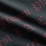 Close up on red text print on the back of a black garment dyed t-shirt