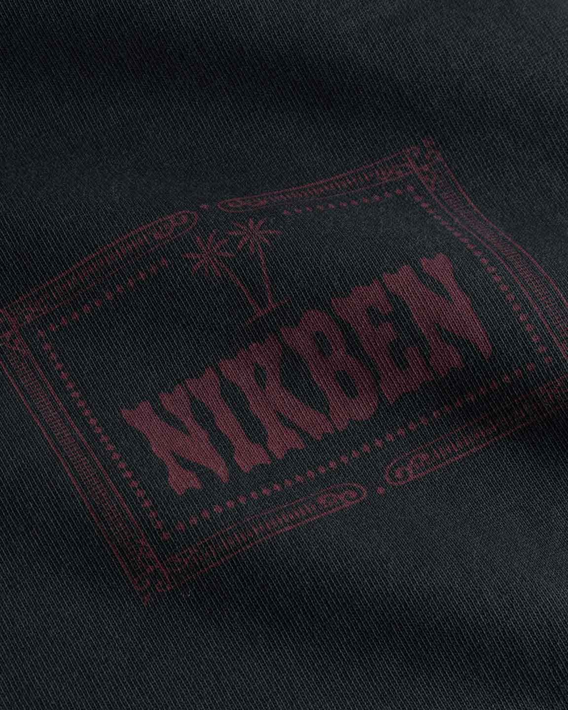 Close up of red chest print on a black garment dyed t-shirt