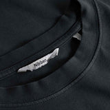 Close-up view of neck label, round neck, and tonal stitchings on a black garment dyed t-shirt