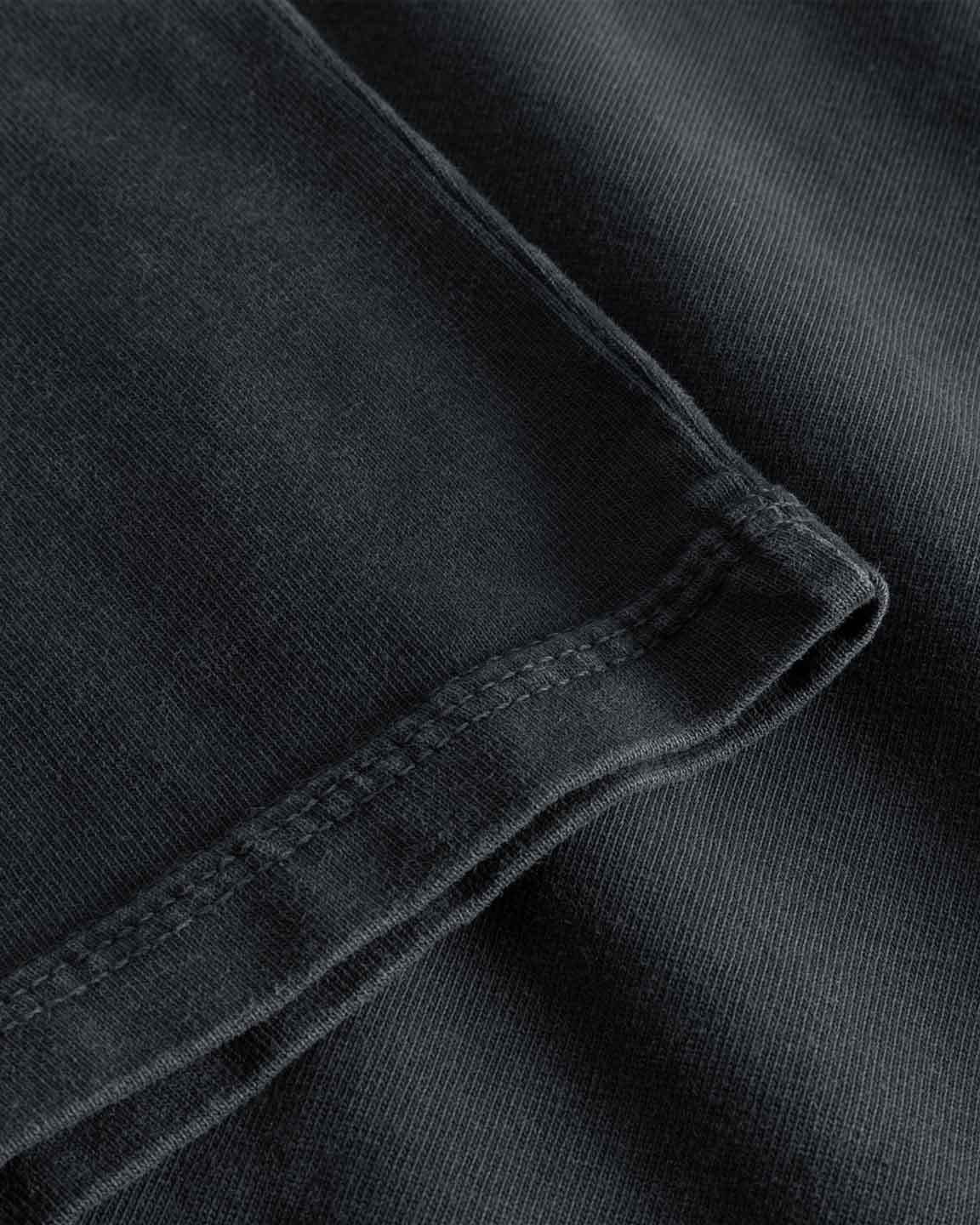 Close up of sleeve and tonal stitchings on a black t-shirt