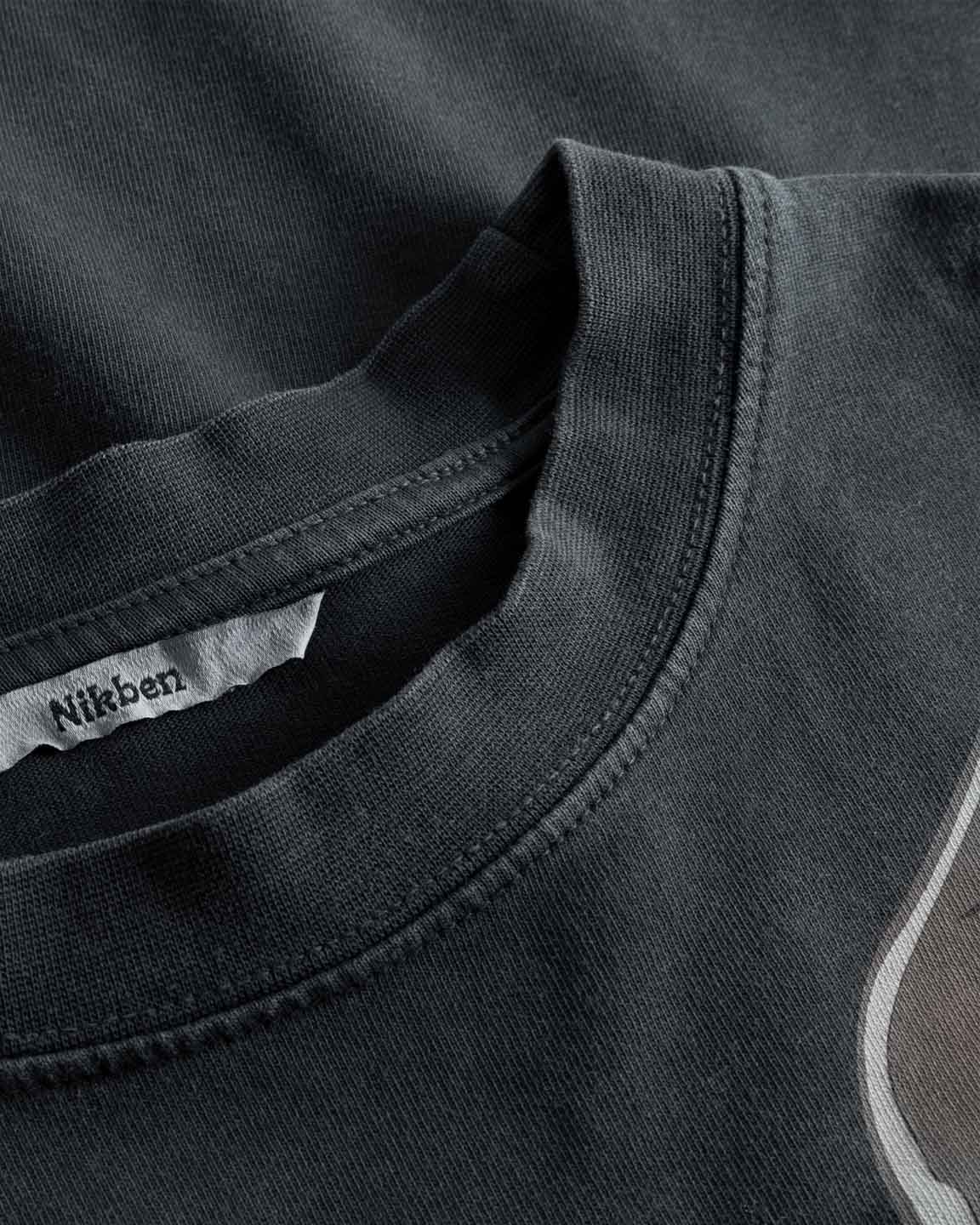 Close-up view of neck label, round neck, and tonal stitchings on a black t-shirt