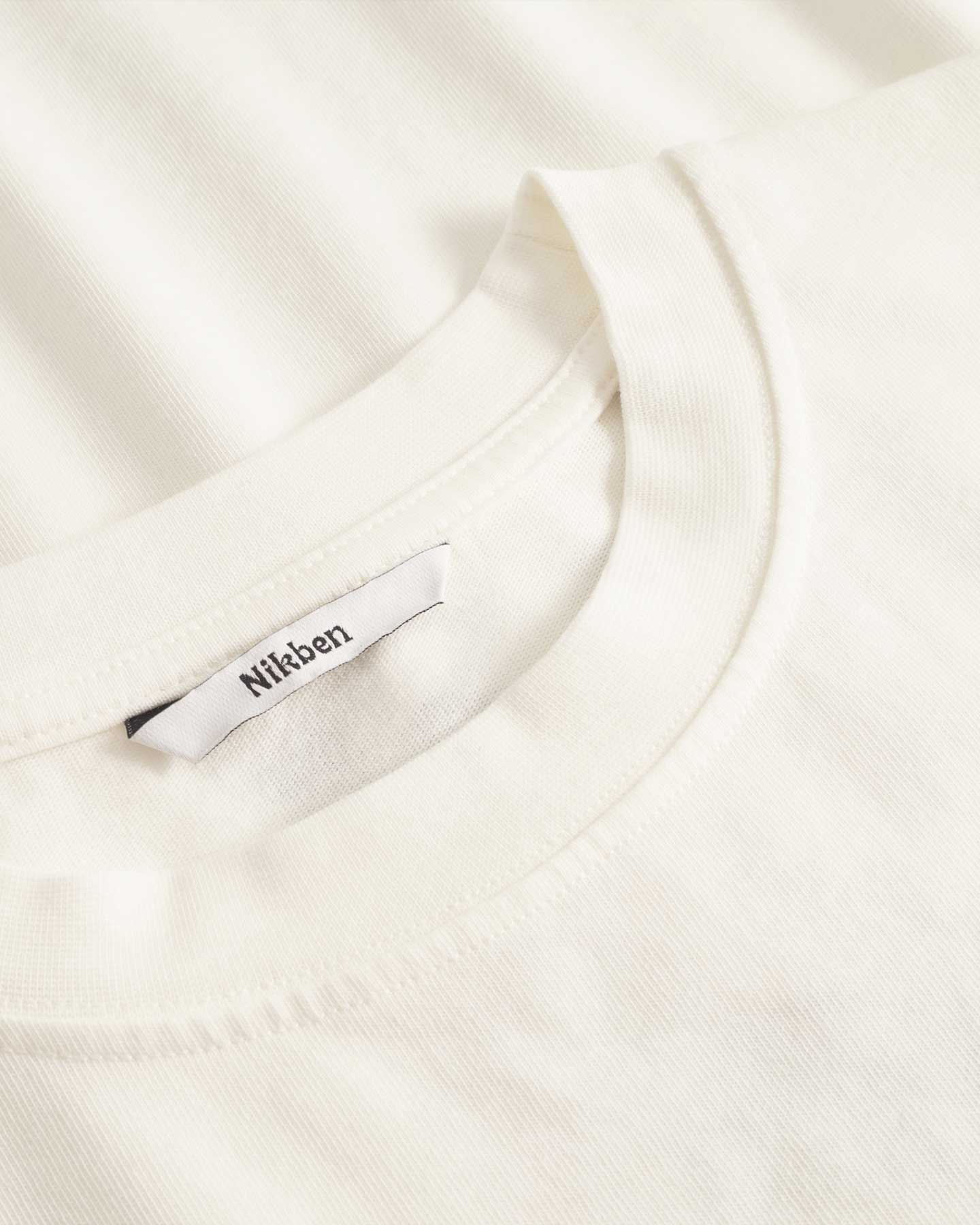 Close up of collar on a cream colored t-shirt