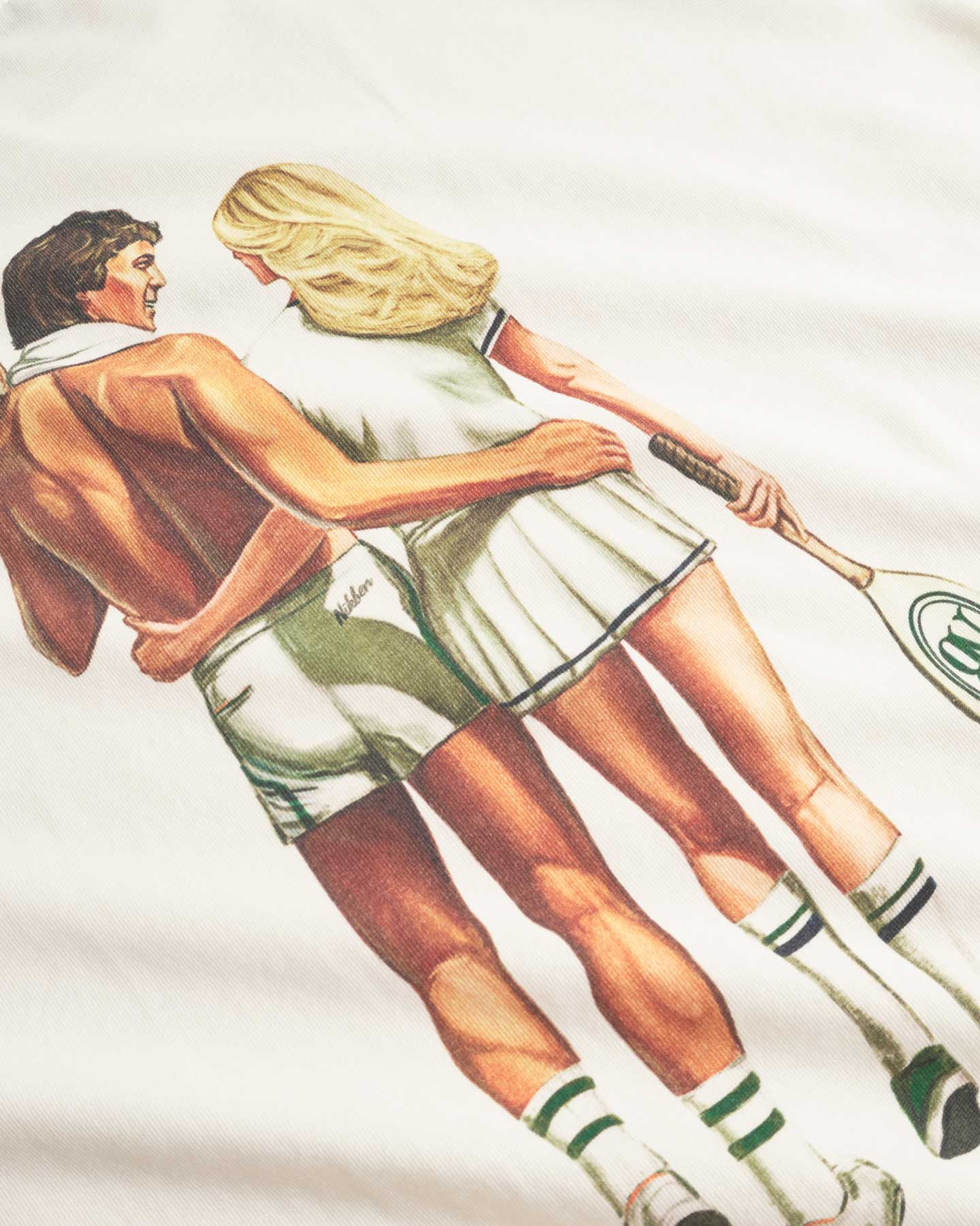 Close up of back of a cream colored t-shirt with male and female tennis players back print 