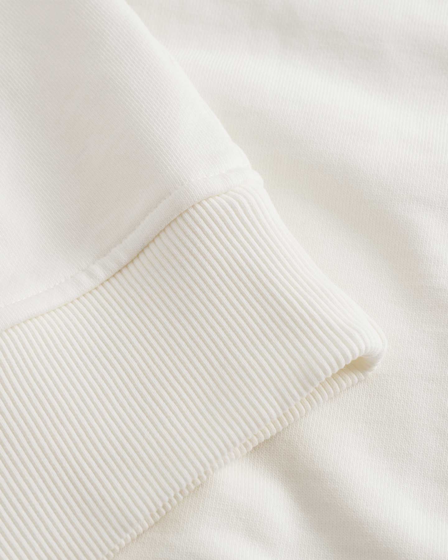 Close up of ribbed cuffs on a cream colored hoodie