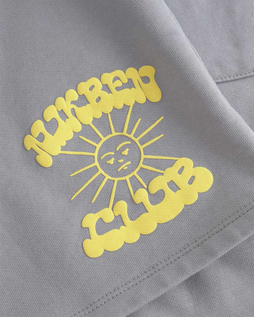 Close up of yellow Nikben Sunshine Club print on grey sweat shorts