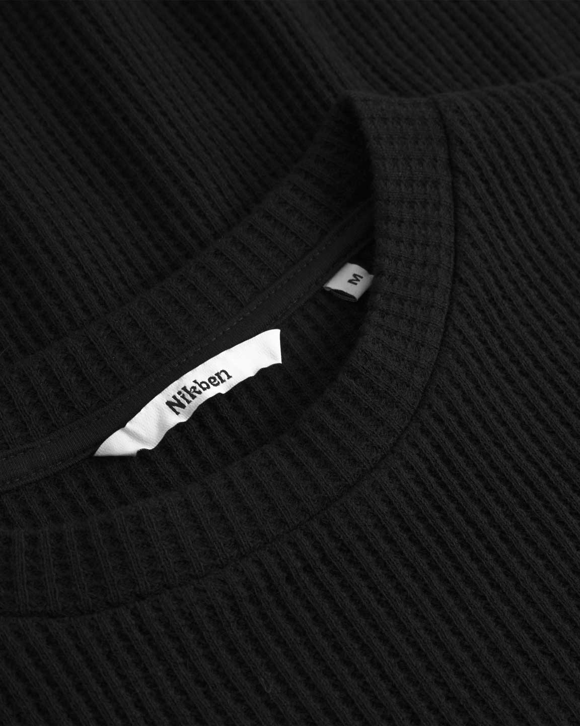 Close up of collar on a black waffle patterned t-shirt