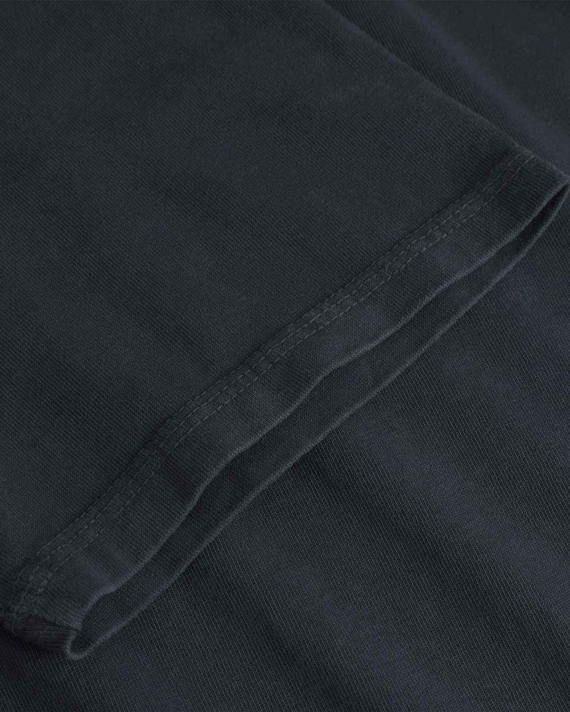 Close up of tonal stitching on a black t-shirt