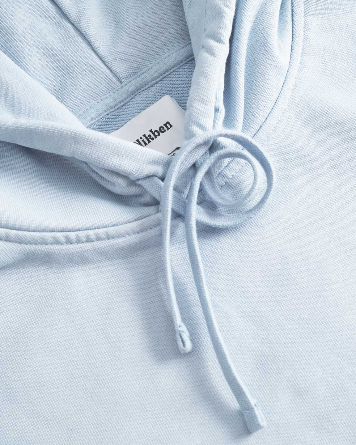 Close up of drawstrings on a baby blue hoodie