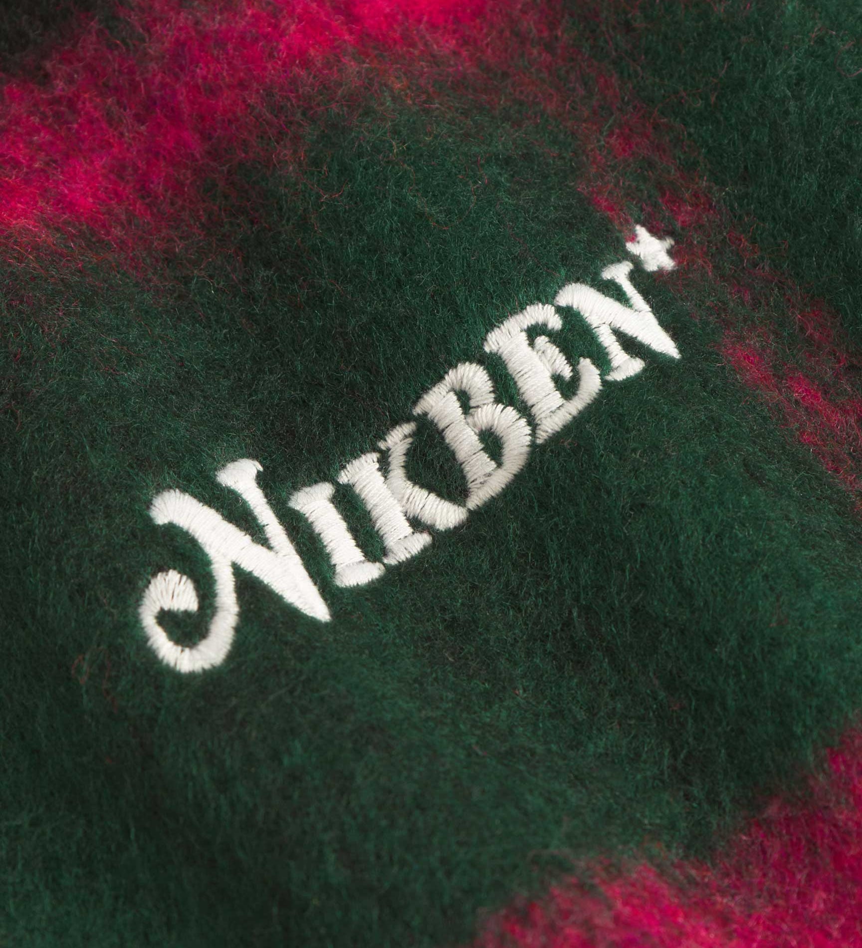 Close up of embroidery on a Green and pink colored lumberjack jacket with pockets