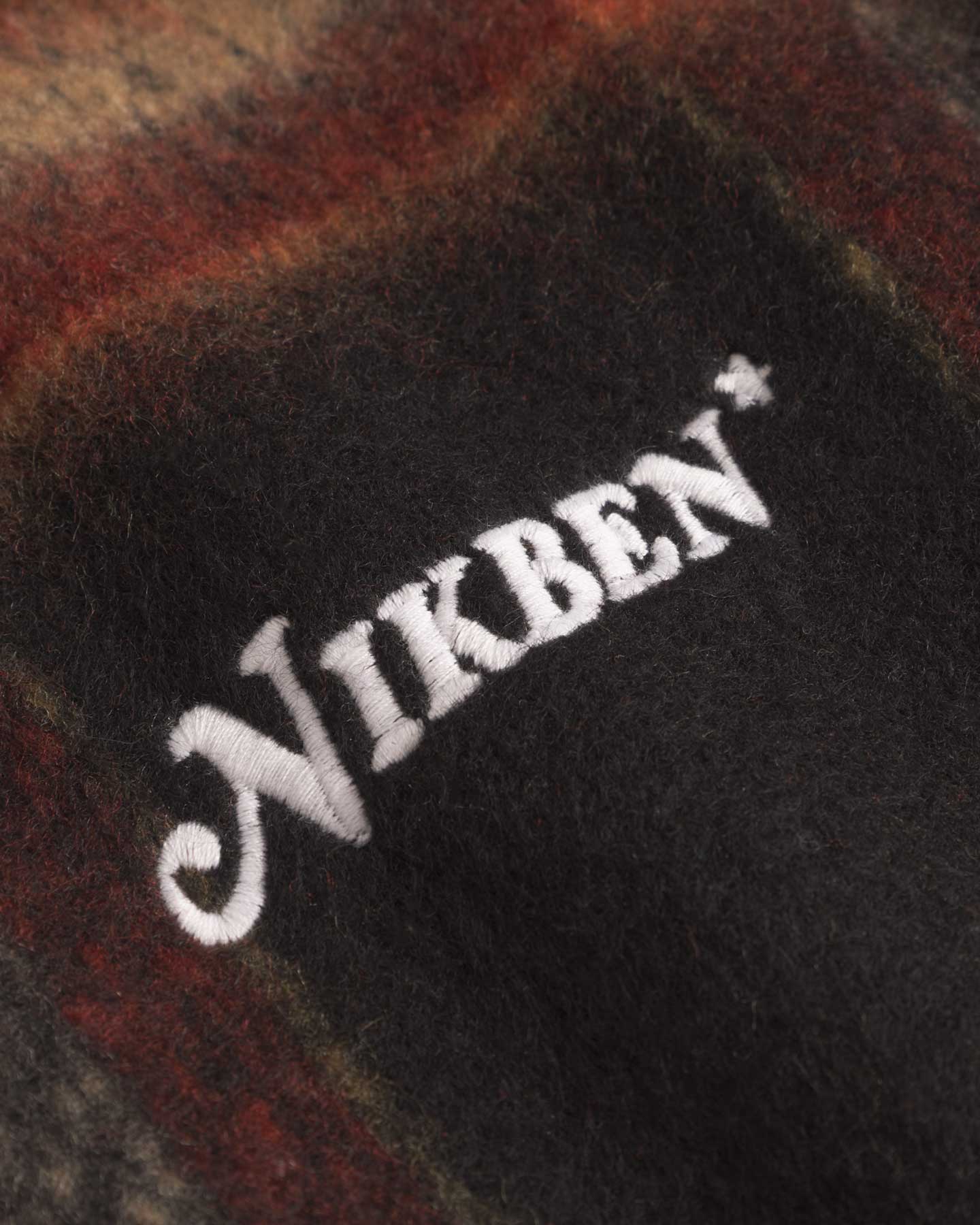 Close up of embroidery on an orange red colored lumberjack jacket