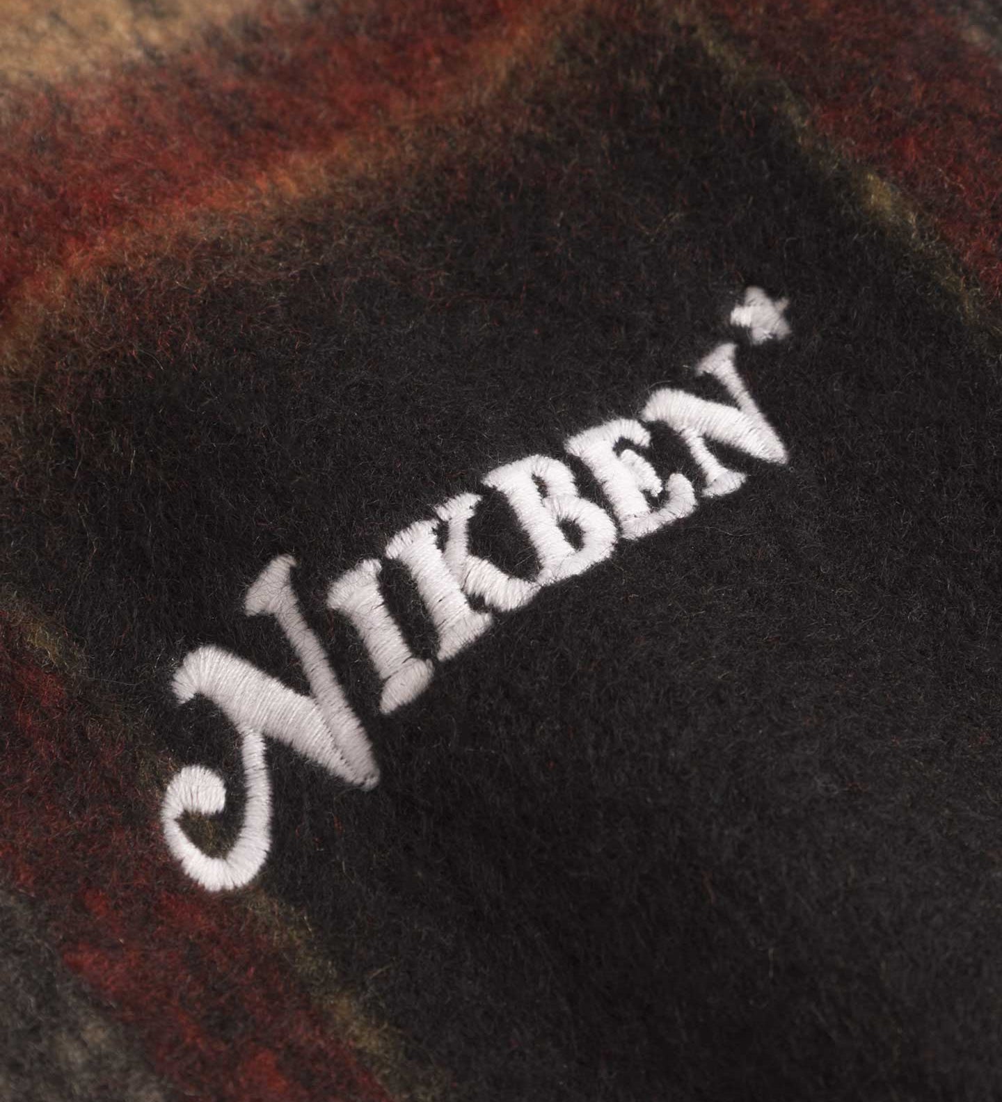 Close up of embroidery on an orange red colored lumberjack jacket