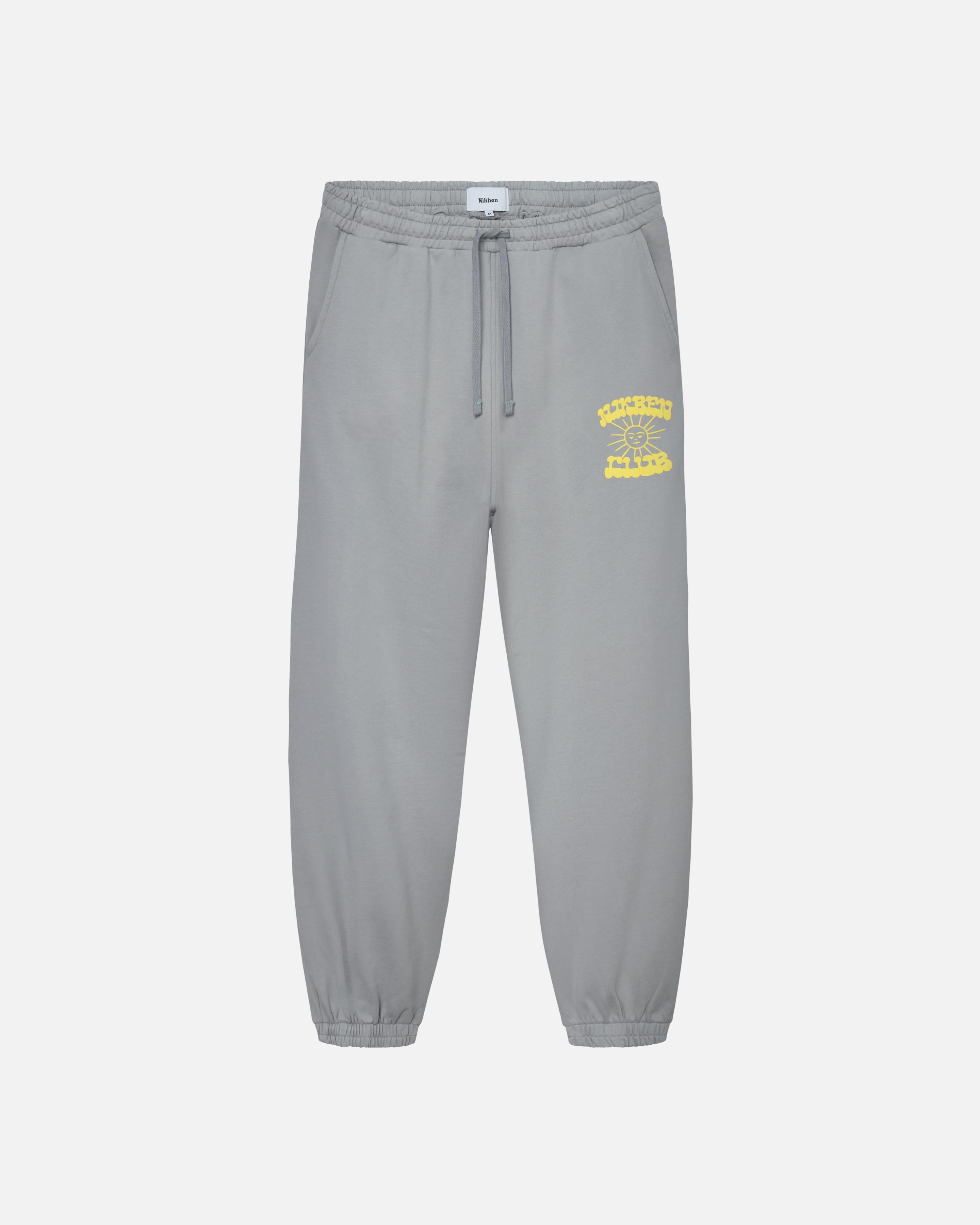 Grey sweat pants with drawstrings, ribbed cuffs and yellow Nikben Sunshine Club print 