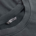 Close-up of black t-shirt with a brand label on the collar.