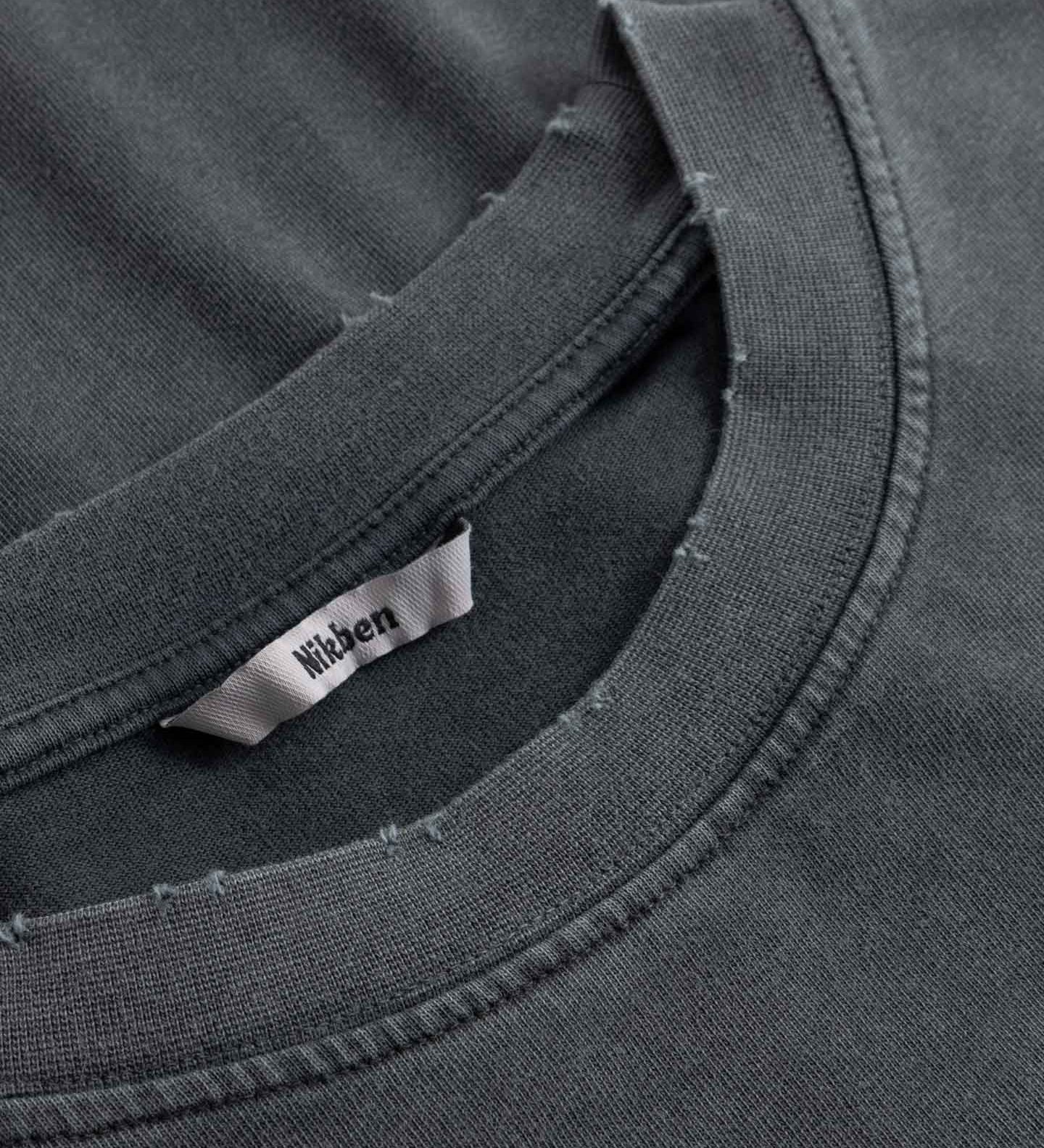 Close-up of black t-shirt with a brand label on the collar.