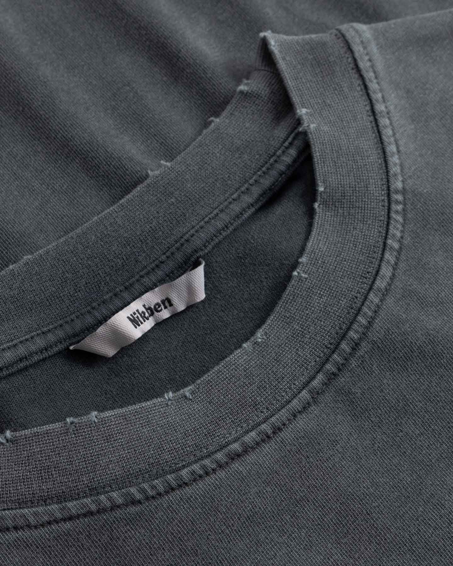 Close-up of black t-shirt with a brand label on the collar.