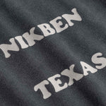 Close up of Text 'NIKBEN TEXAS' printed on black fabric.