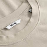 Close-up of a beige t-shirt with a brand label on the collar.