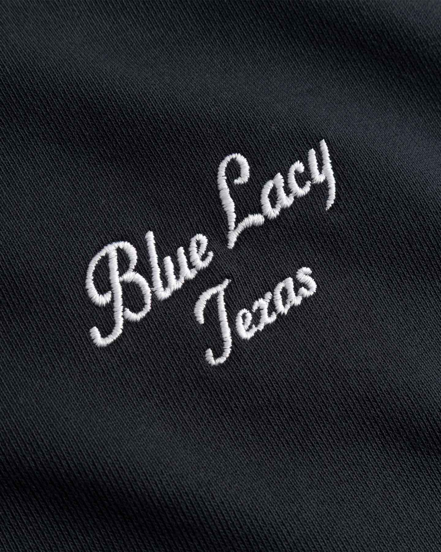 Embroidered white text 'Blue Lacy Texas' on a black background