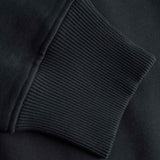 Close-up of a black sweatshirt with ribbed cuffs and hem.