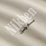 Close up of small logo on beige t-shirt