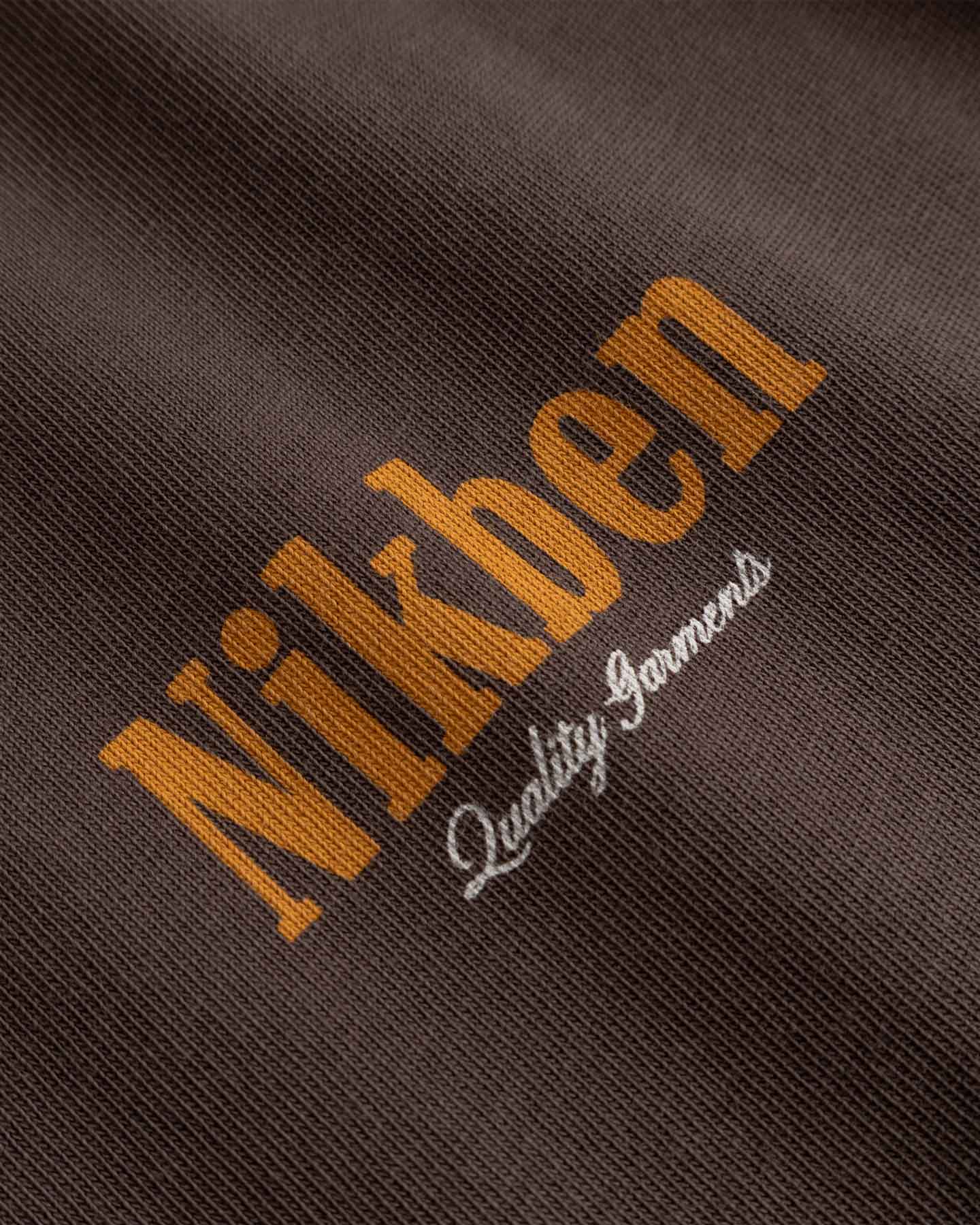 Close-up of 'Nikben' logo on a textured brown fabric 
