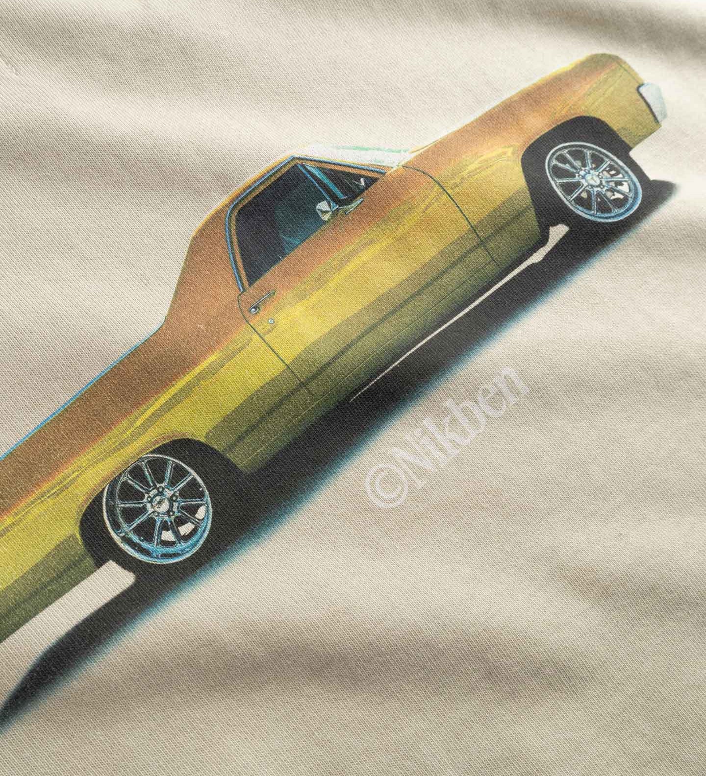 Close up of yellow car graphic on a beige fabric
