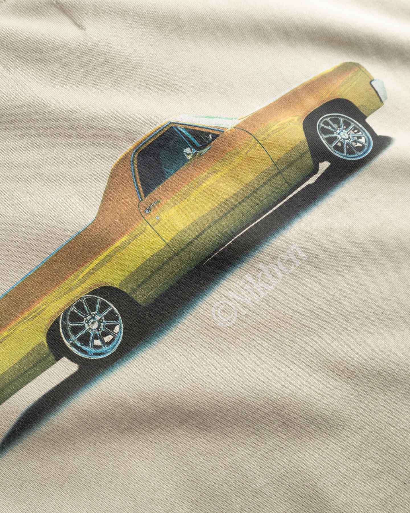 Close up of yellow car graphic on a beige fabric