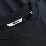 Close-up of a black t-shirt with a visible brand label on the collar.
