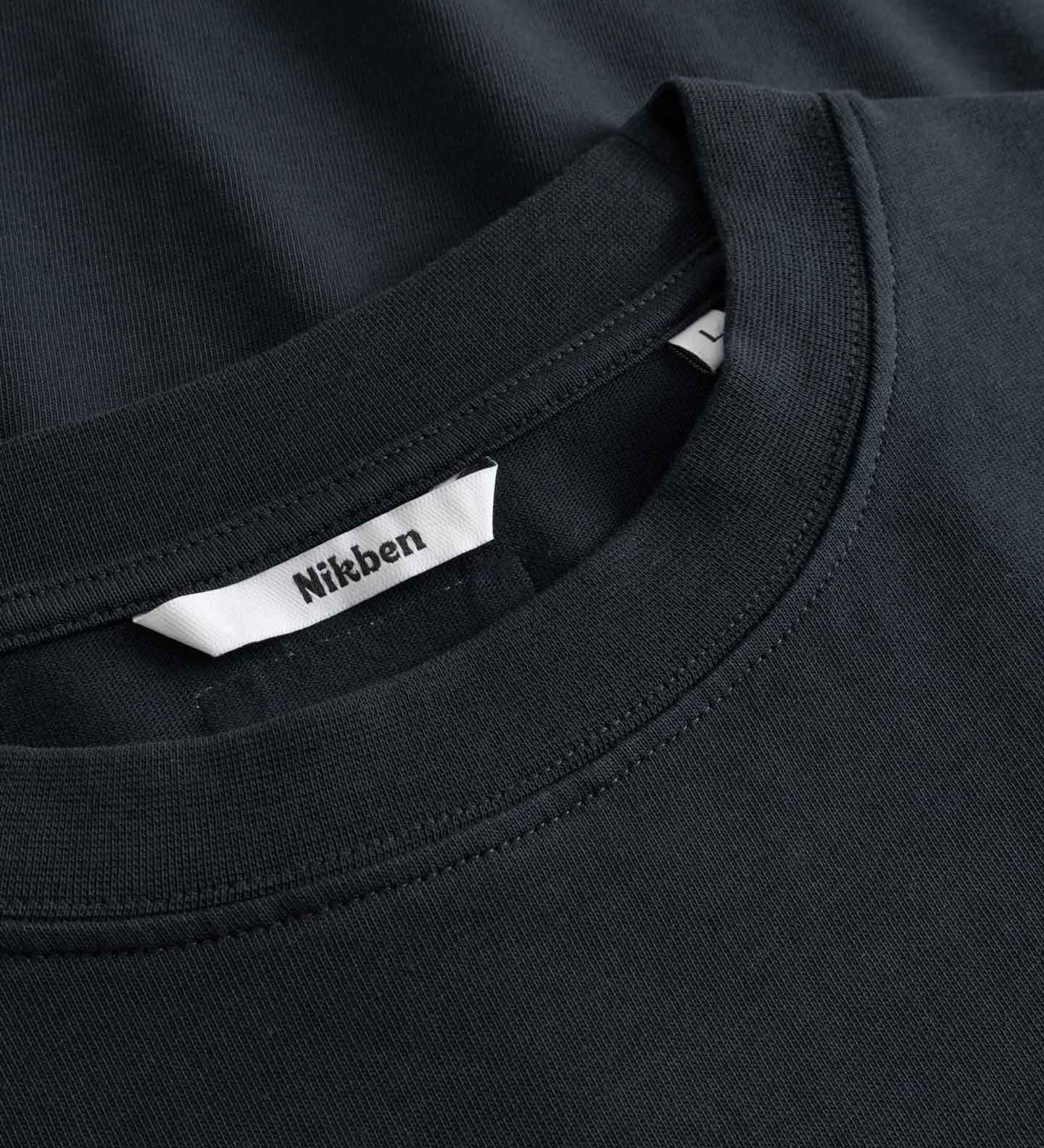 Close-up of a black t-shirt with a visible brand label on the collar.