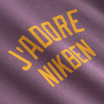 Text 'J'ADORE NIKBEN' printed on purple fabric 