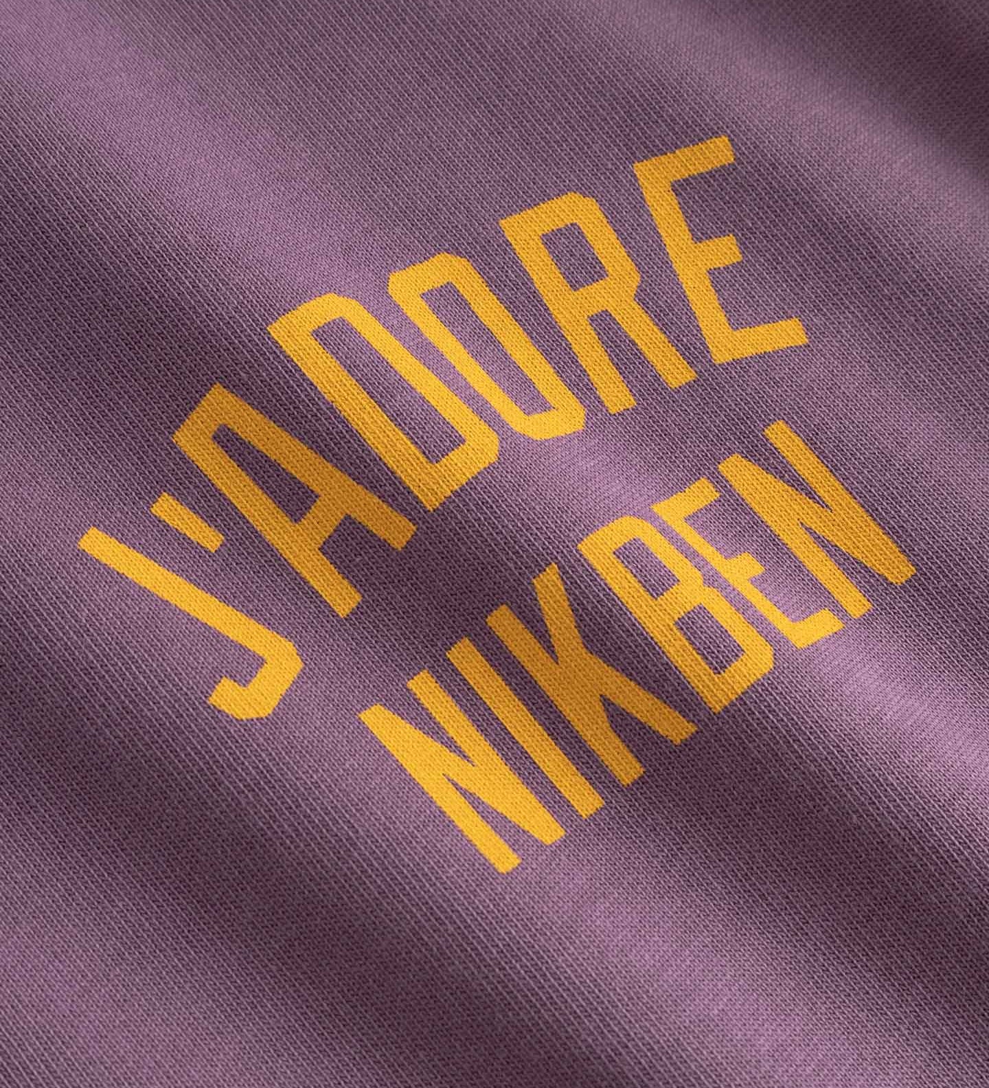 Text 'J'ADORE NIKBEN' printed on purple fabric 