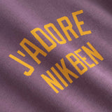 Text 'J'ADORE NIKBEN' printed on purple fabric 