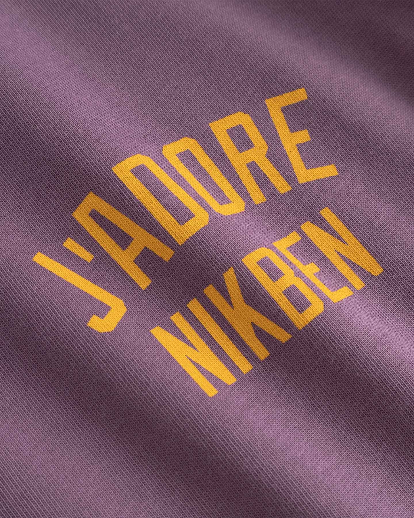 Text 'J'ADORE NIKBEN' printed on purple fabric 