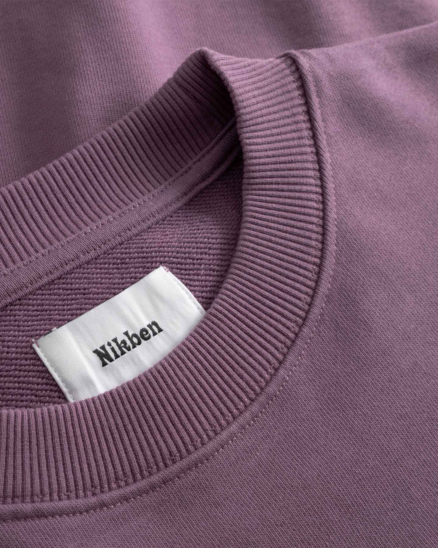 Close-up of purple sweatshirt with visible 'Nikben' label.