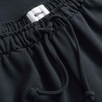 Black pants with drawstring and visible brand label 