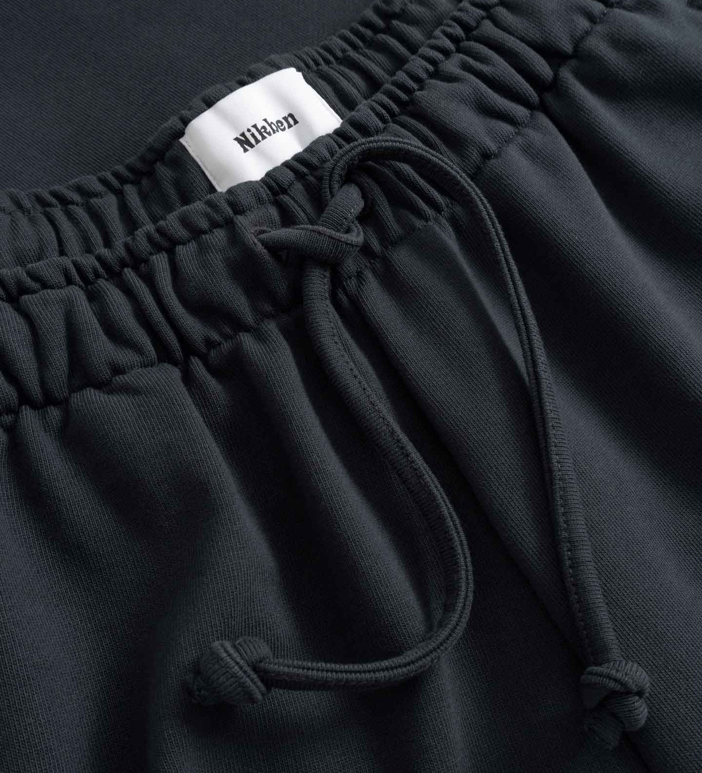Black pants with drawstring and visible brand label 