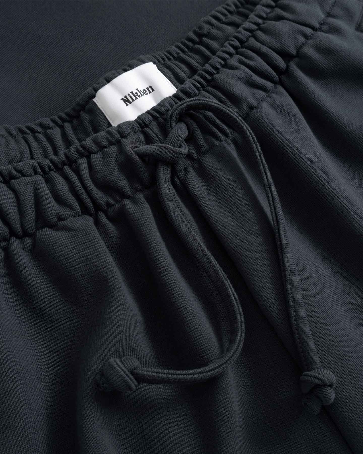 Black pants with drawstring and visible brand label 