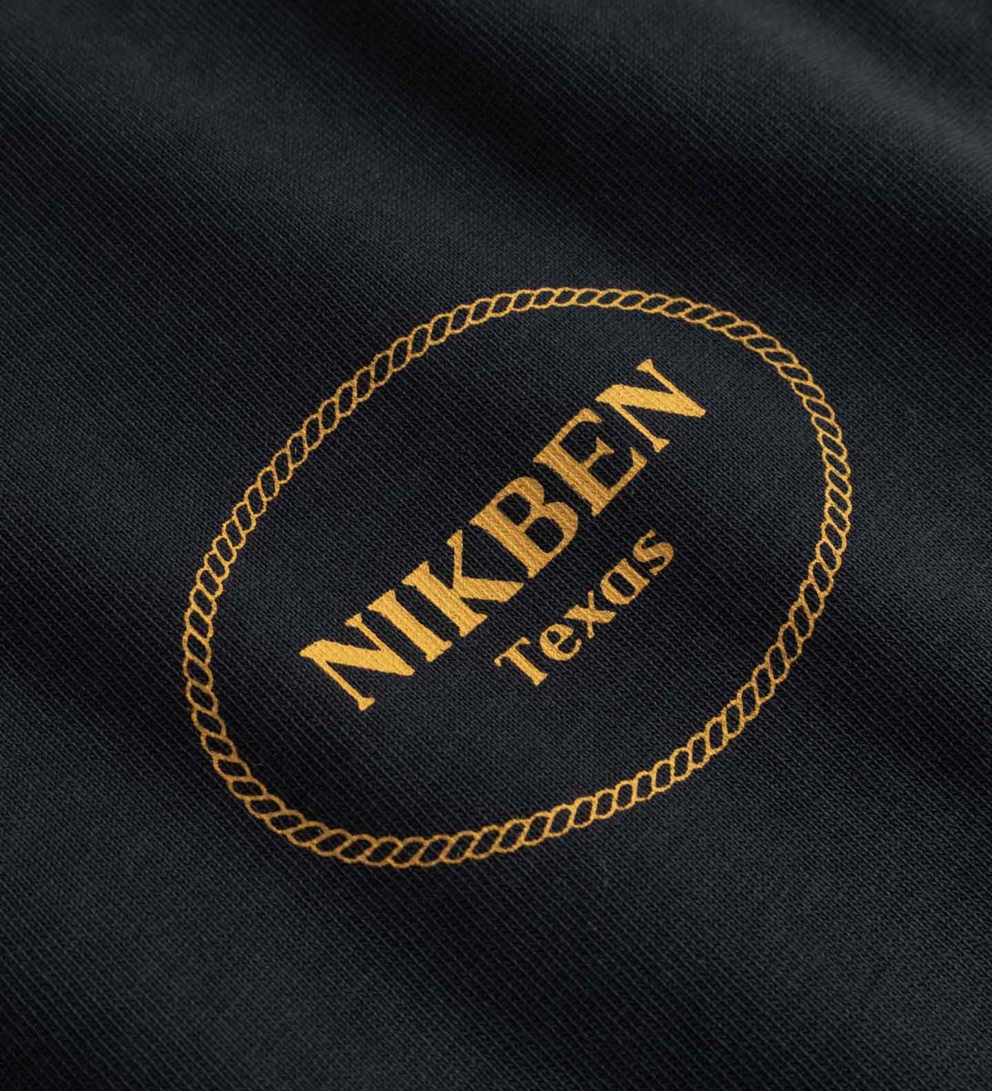 Close Up Of Small Yellow Logo on chest of Black - T-shirt 