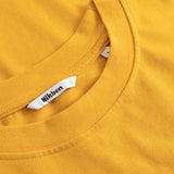 Close-up of a yellow shirt with a visible brand tag.