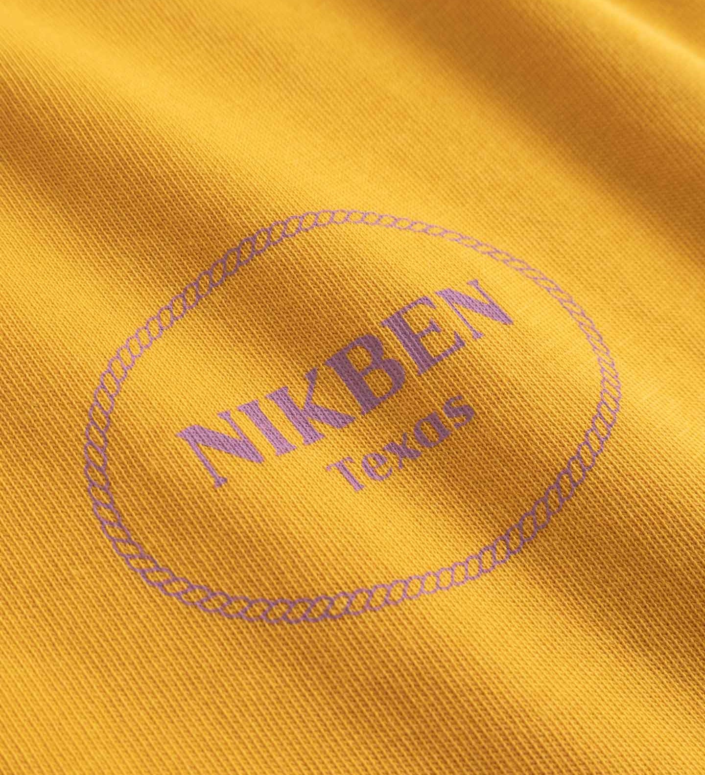 Close-up of a yellow fabric with 'NIKBEN Texas' printed on it.