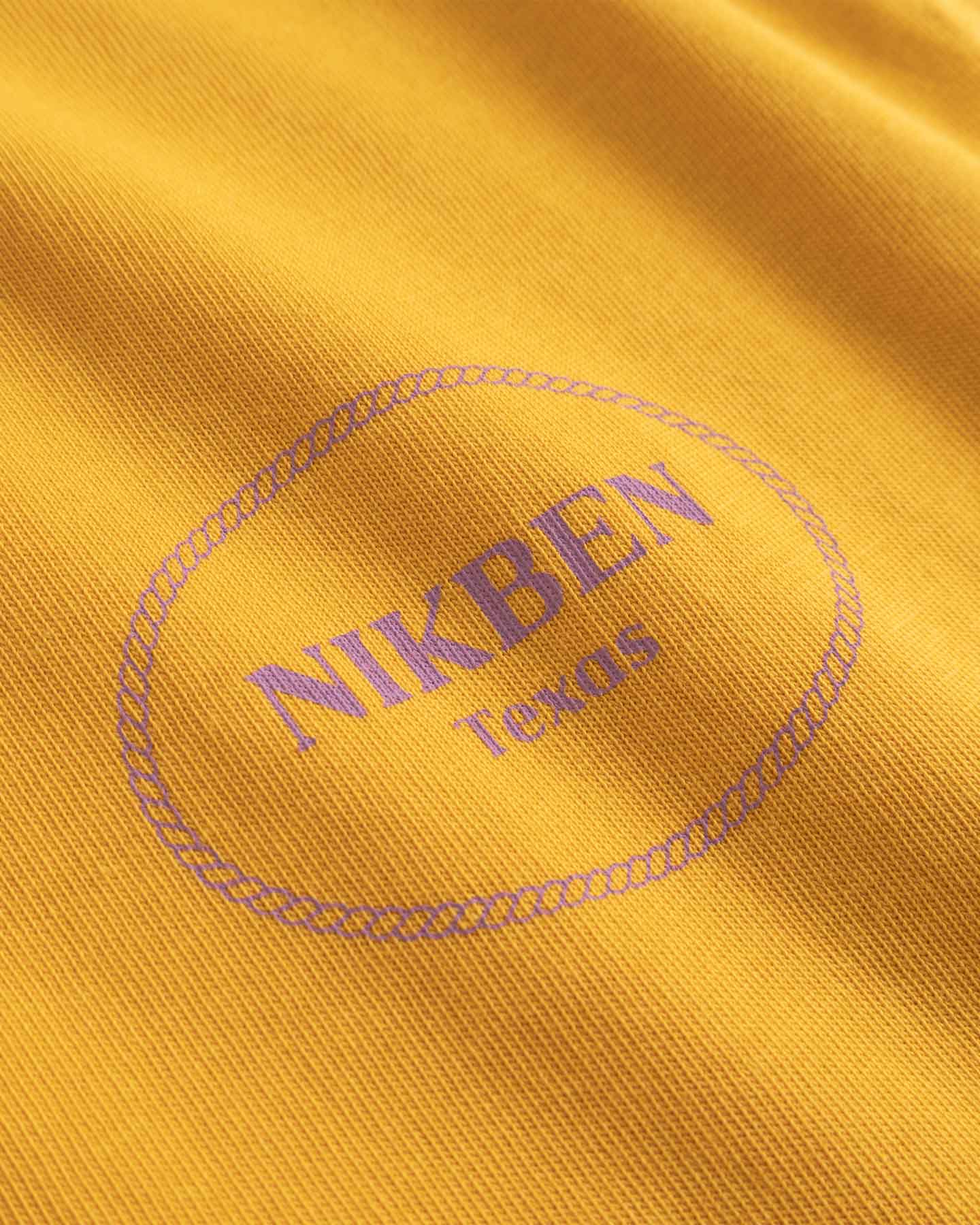 Close-up of a yellow fabric with 'NIKBEN Texas' printed on it.