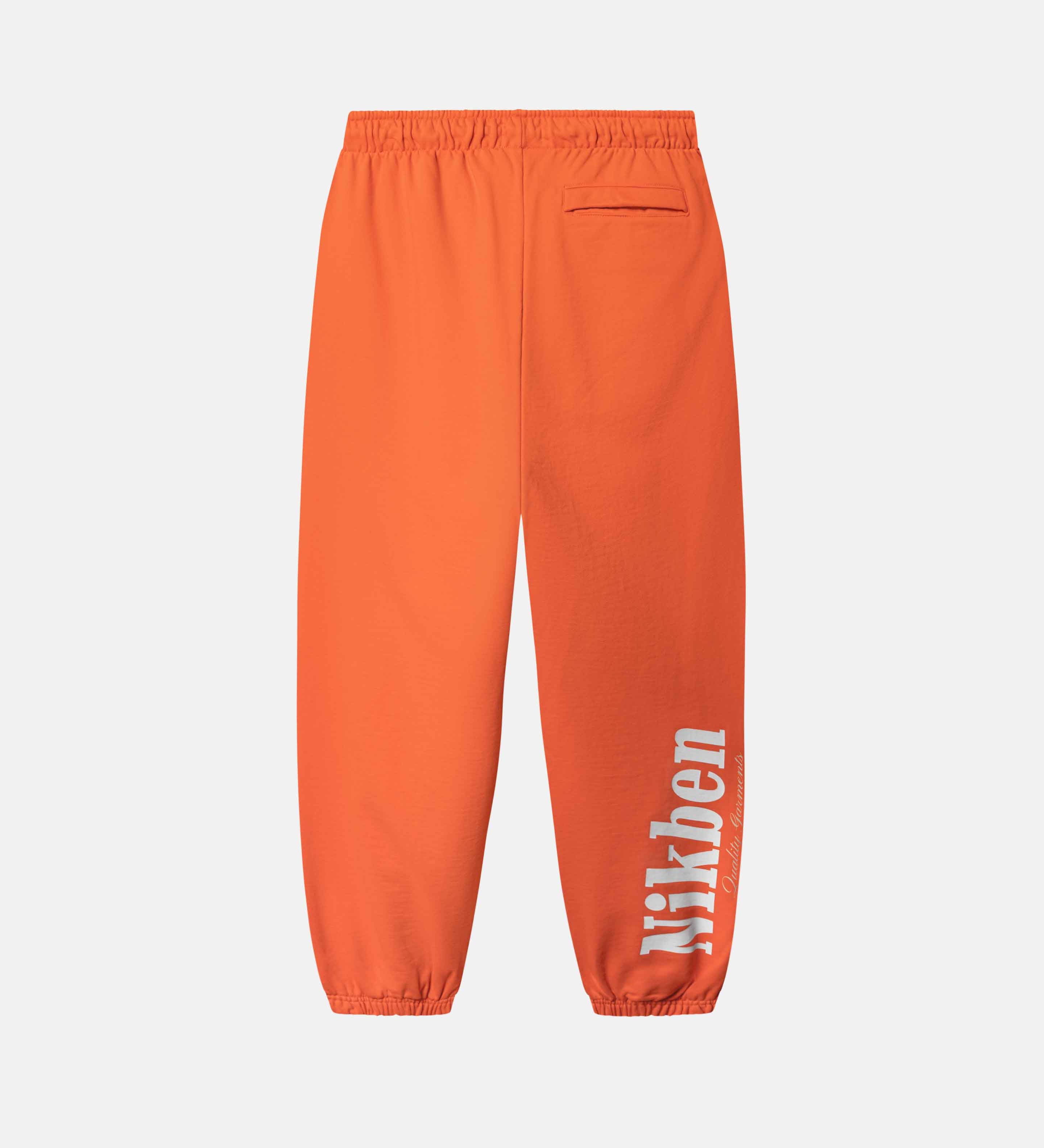 Orange pants with a brand logo on side 
