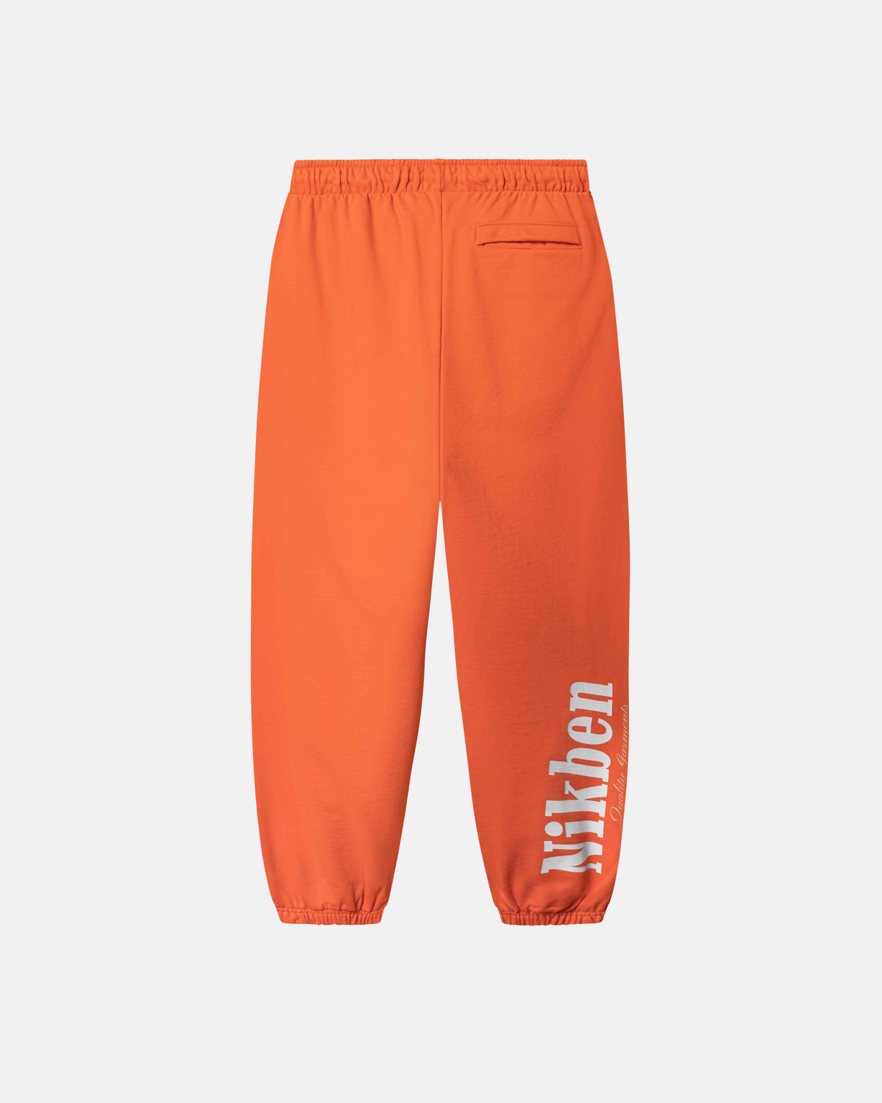 Orange pants with a brand logo on side 