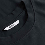 Close-up of a black shirt with a visible brand label.