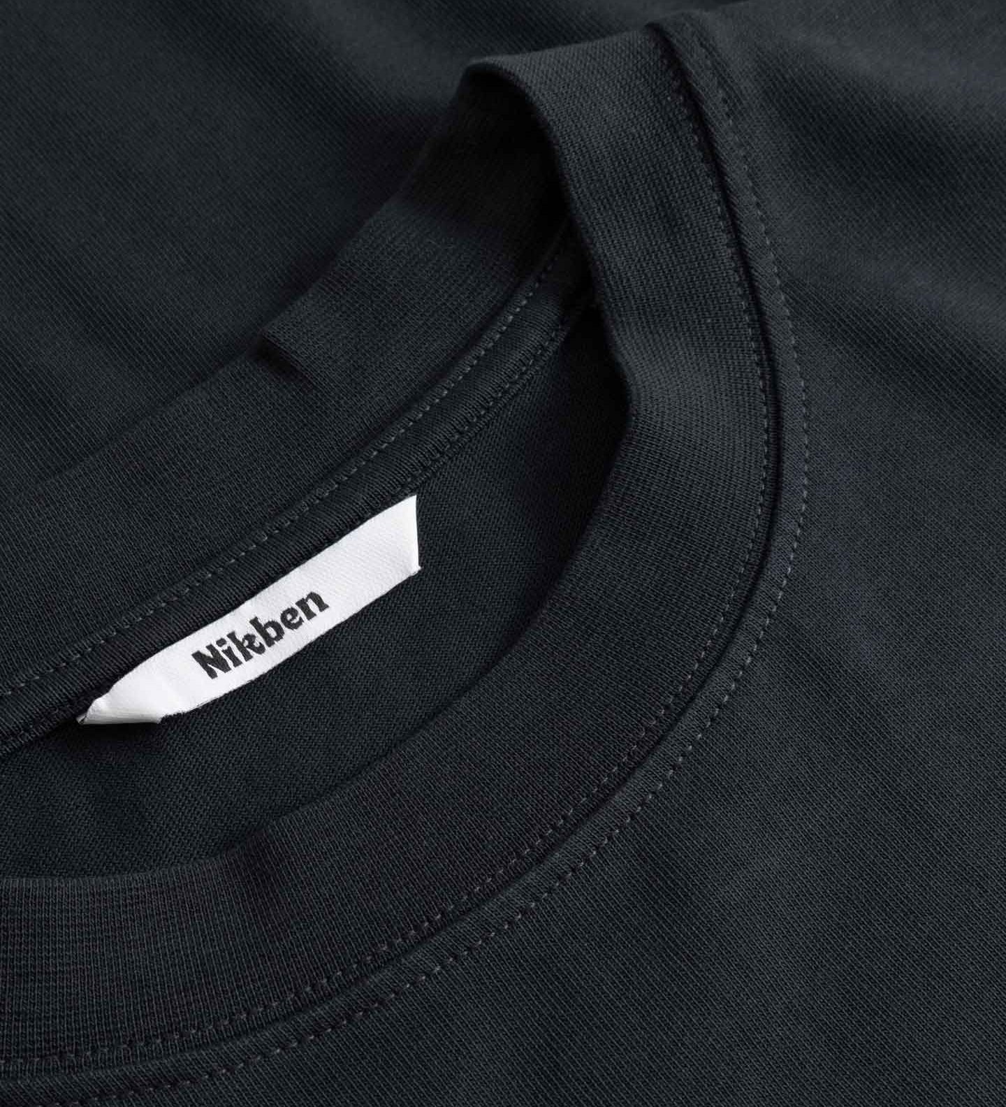 Close-up of a black shirt with a visible brand label.