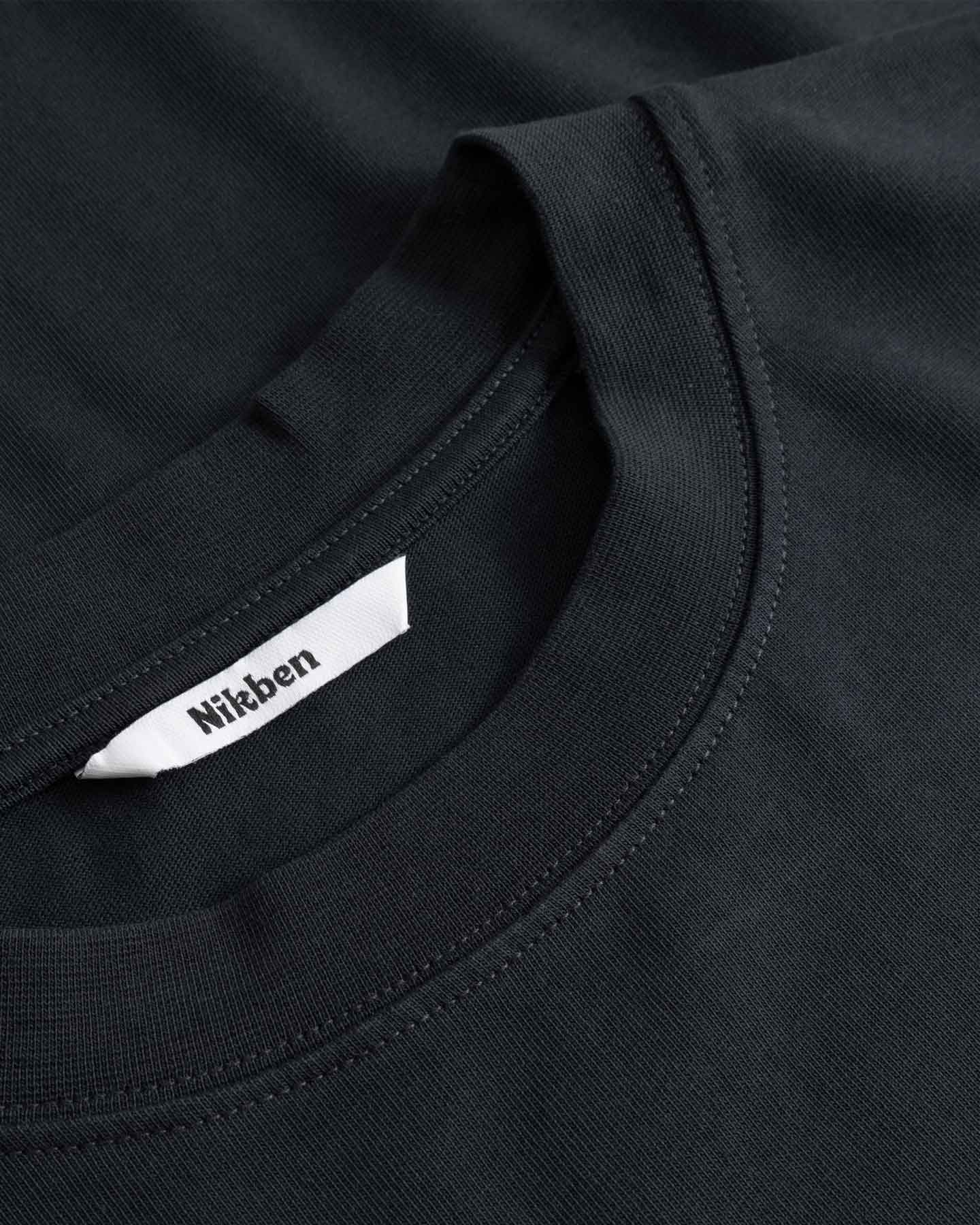Close-up of a black shirt with a visible brand label.