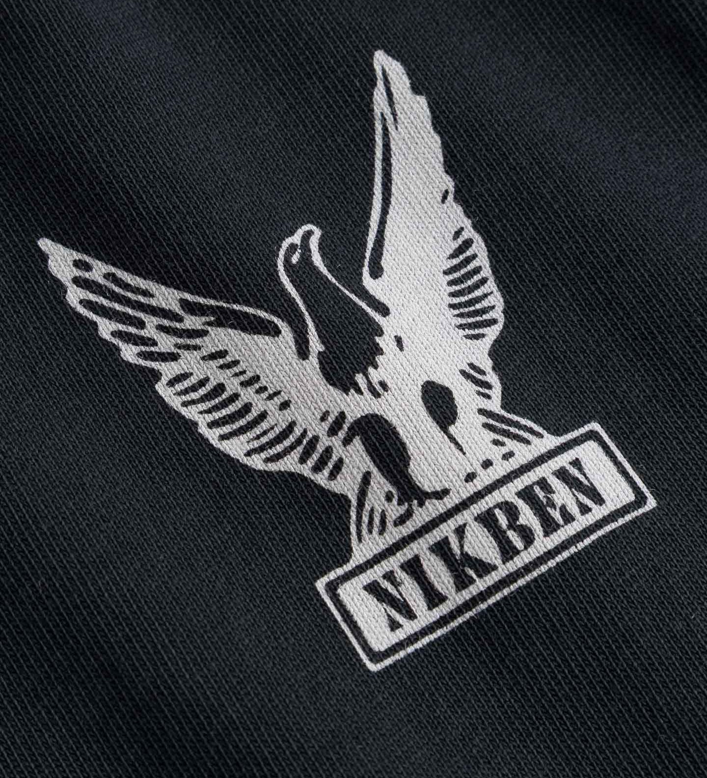 Nikben logo with an eagle design on black fabric
