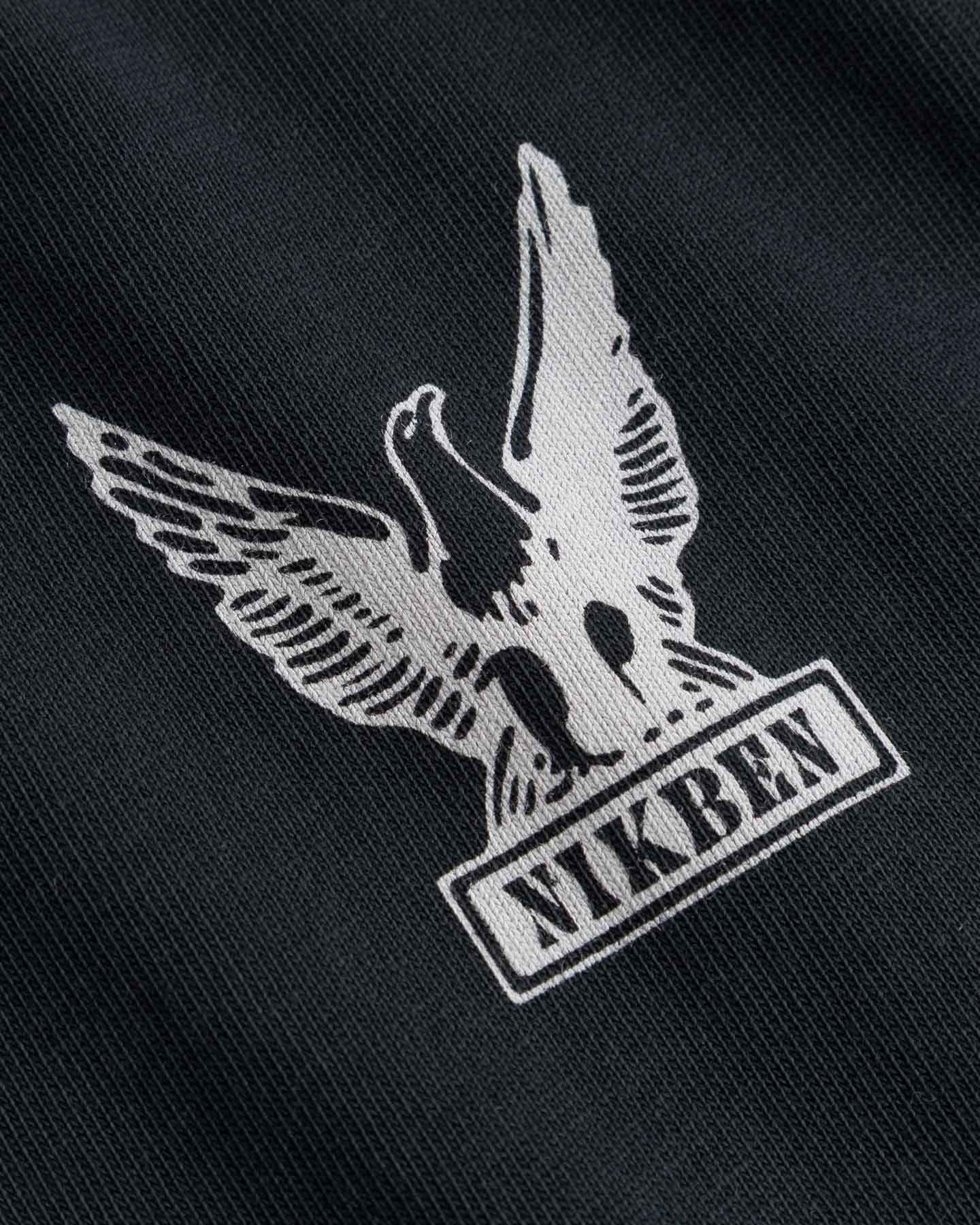 Nikben logo with an eagle design on black fabric